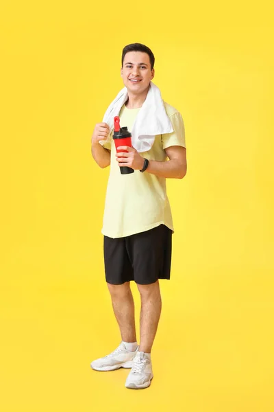 Sportlicher Männertrainer Mit Flasche Wasser Auf Farbigem Hintergrund — Stockfoto