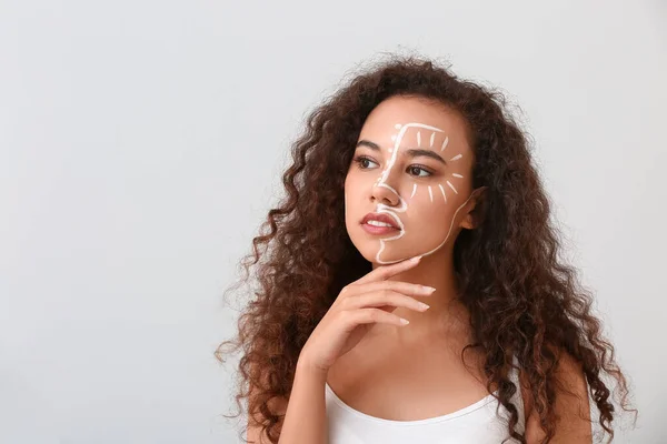 Beautiful Young African American Woman Paint Her Face Light Background — Stock Photo, Image