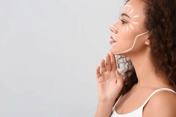 Beautiful Young African American Woman Paint Her Face Light Background — Stock Photo, Image