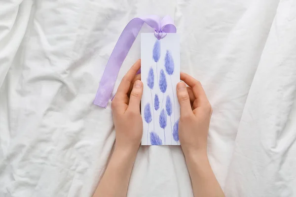 Woman with bookmark on bed