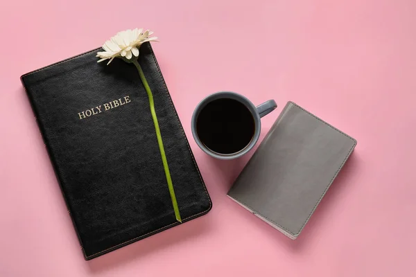 Holy Bible, cup of coffee and flower on color background