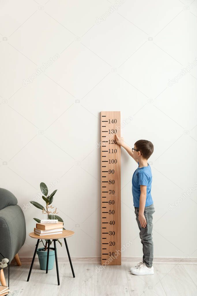 Little boy measuring height at home