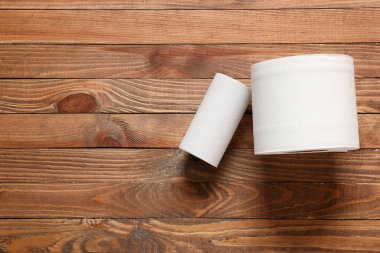 Tahta arka planda tuvalet kağıdı ve karton tüp.