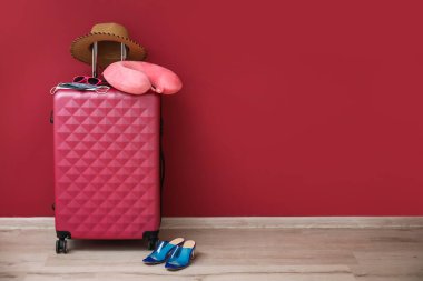 Bağışıklık pasaport, tıbbi maske ve seyahat aksesuarlarıyla dolu bavul renkli duvarın yanında.