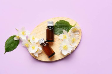 Renkli arka planda gerekli yağ ve yasemin çiçeklerinin bulunduğu tahta