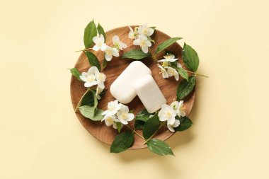 Arkaplanda sabun kalıpları ve yasemin çiçekleri olan tabaklar