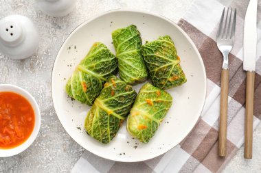 Doldurulmuş lahana yapraklı tabak ve grunge arkaplanda domates sosu.