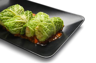 Beyaz arka planda domates soslu lahana dolması.