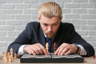 Oyun tahtasında satranç taşları olan adam, yakın plan