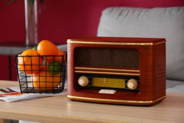 Retro radyo alıcısı ve oturma odasındaki meyveli sepet.
