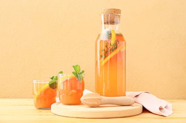 Renkli arka planda bardaklar ve bir şişe lezzetli greyfurt suyu