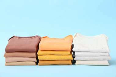 Renkli arka planda bebek kıyafetleri yığını