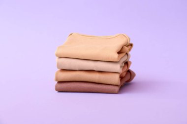 Renkli arka planda bebek kıyafetleri yığını