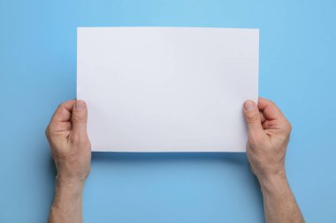 Renk arkaplanı üzerine boş kağıt tutan adam, yakın plan