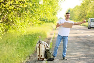 Kartondan otostop çeken genç bir adam.