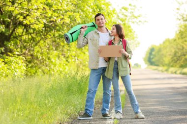 Kartondan otostop çeken genç bir çift.