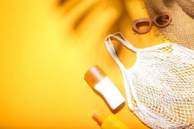 Renkli arka planda plaj aksesuarları ve kozmetik ürünleri