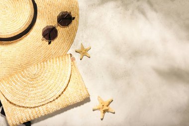 Hafif arkaplanda şık şapka, çanta ve güneş gözlüğü