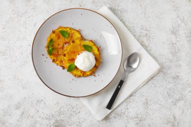 Izgara ananas dilimleri ve hafif arka planda dondurma tabağı.