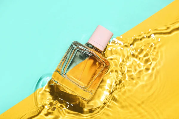 水の中の香水のボトルの色の背景 — ストック写真