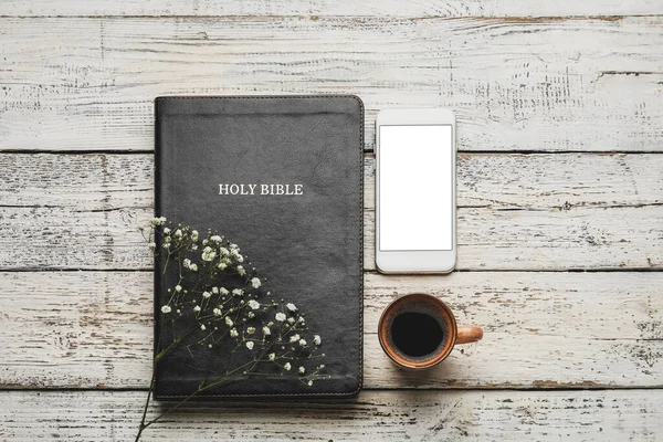 神圣的圣经 一杯咖啡 手机和轻型木制背景的花朵 — 图库照片