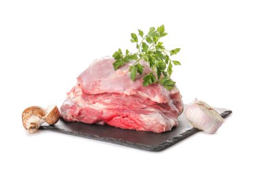 Beyaz arka planda çiğ domuz eti, maydanoz, sarımsak ve mantar tabağı.