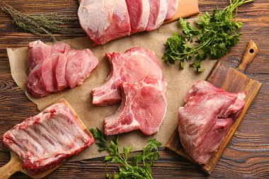 Ahşap zeminde çiğ domuz eti ve maydanoz dilimleri.