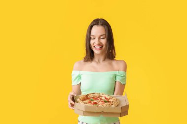 Renkli arkaplanda lezzetli pizzası olan güzel bir kadın.