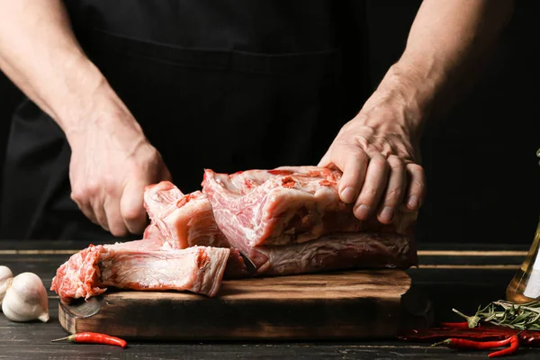 Man Cutting Raw Pork Meat Dark Wooden Table Closeup — Stock Photo, Image
