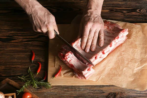 Man Cutting Raw Pork Ribs Wooden Table — Stock Photo, Image