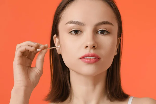 Mujer Joven Limpiando Orejas Con Capullo Algodón Sobre Fondo Color — Foto de Stock