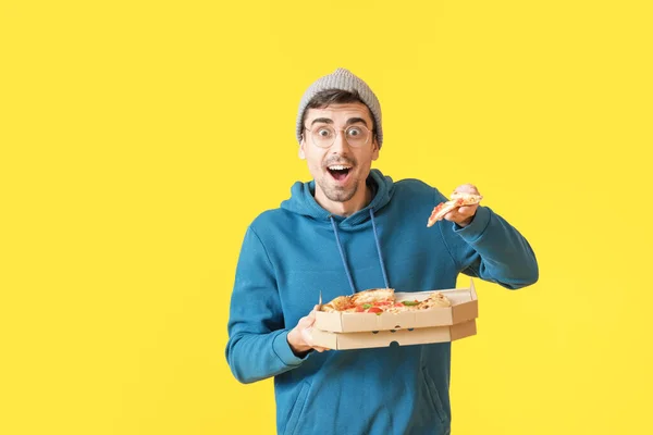 Překvapený Mladý Muž Chutnou Pizzu Barevném Pozadí — Stock fotografie