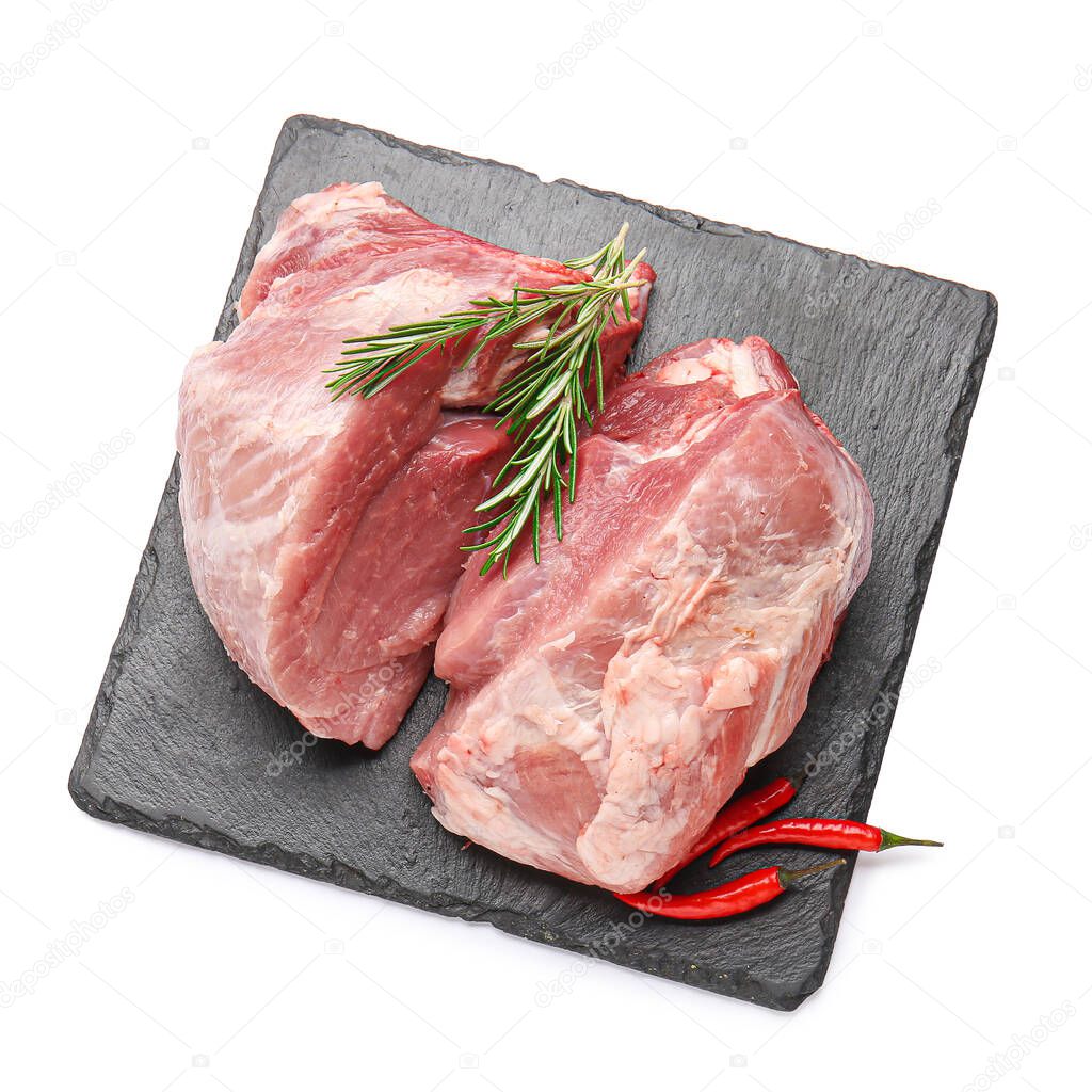 Slate plate with raw pork meat, rosemary and chili pepper on white background