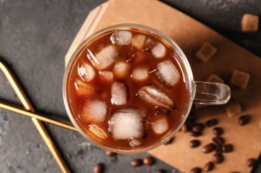 Bir fincan buzlu kahve ve arkaplanda fasulye.