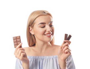 Beyaz arka planda lezzetli çikolataları olan güzel genç bir kadın.