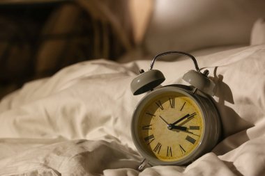 Gece yataktaki çalar saat, yakın plan.