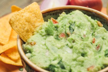 Lezzetli guacamole ve nacho ile kase, yakın plan.