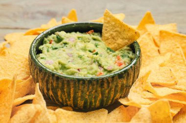 Lezzetli guacamole ve nachos ile bir kase masa, yakın plan