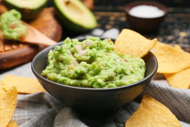 Lezzetli guacamole ve nachos ile bir kase masa, yakın plan
