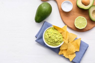 Lezzetli guacamole ve hafif ahşap arka planda nachos ile kase