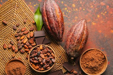 Taze kakao meyveleri, fasulye, çikolata ve arkaplanda pudra içeren kompozisyon
