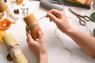 Kadın arka planda mum yapıyor.