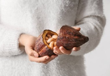 Elinde taze kakao meyvesi tutan kadın, yakın plan.