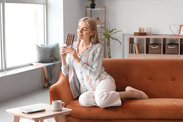 Beautiful Young Woman Eating Tasty Chocolate Home — Stock Photo, Image