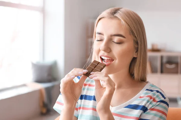 Beautiful Young Woman Eating Tasty Chocolate Home — Stock Photo, Image