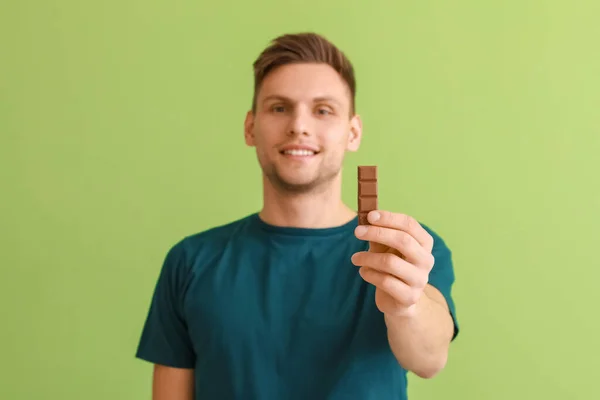 Joven Guapo Con Sabroso Chocolate Sobre Fondo Color — Foto de Stock