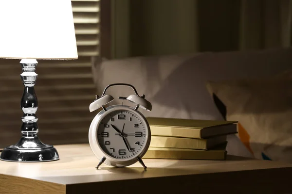 Wecker Mit Lampe Und Büchern Auf Dem Tisch Schlafzimmer Nachts — Stockfoto