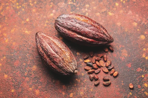 Fresh cocoa fruits and beans on grunge background