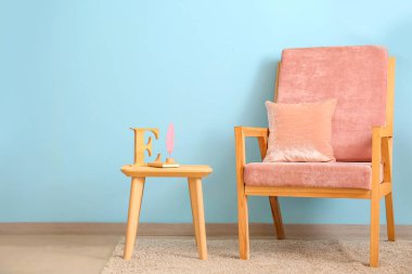 Renkli duvarın yanında şık bir koltuk ve masa