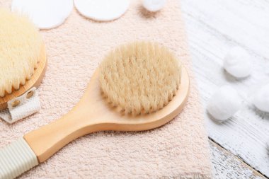 Hafif ahşap arka planda masaj fırçaları ve banyo malzemeleri, yakın plan